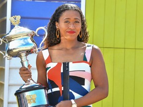 Japan's Naomi Osaka poses for photographs with the championship trophy at the Brighton Beach in Melbourne on January 27, 2019, a day after her victory against Czech Republic's Petra Kvitova in the women's singles final at the Australian Open tennis tournament. (Photo by Saeed KHAN / AFP)