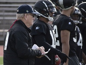 In this Jan. 20, 2019, photo released by the Alliance of American Football, Bill Polian, Alliance of American Football head of football and co-founder, left, watches as players with the Birmingham Iron practice in San Antonio.