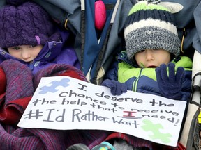 Amara LeBlanc, 4, and her friend Kevin Maillot, 4, sit in a stroller while their parents protest. Both have autism. Their sign reads: "I deserve the chance to receive the help that I need. # I'd rather wait. For the second time in a week, about 40 protesters showed up at Ontario MPP Lisa McLeod's Barrhaven office to protest against the changes made to funding for autistic children. (Julie Oliver/Postmedia)