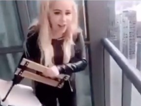 A woman throws a deck chair from a highrise condo balcony towards the Gardiner Expressway in Toronto in video posted to social media.