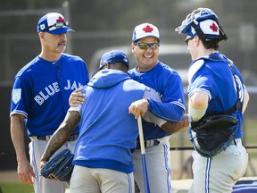 Toronto Blue Jays pitcher Marcus Stroman, second left, hugs manager Charlie Montoyo as pitching coach Pete Walker, left, and catcher catcher Danny Jansen, right, look on after Stroman's bullpen session during baseball spring training in Dunedin, Fla., on Saturday, February 16, 2019. THE CANADIAN PRESS/Nathan Denette