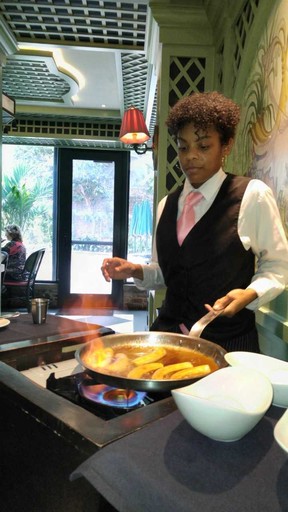 An employee makes bananas Foster at Brennan’s. (DAVE POLLARD)