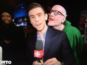 A man identified as comic actor Boyd Banks licks CBC reporter Chris Glover live on air.