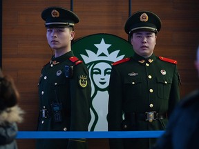 Paramilitary police officers stand guard near a Starbucks cafe in Beijing Railway Station in Beijing on February 2, 2019. (GREG BAKER/AFP/Getty Images)