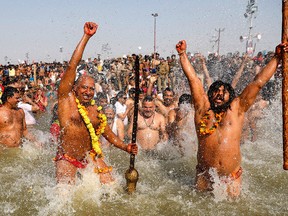 Hindu holy men take ritualistic dip on the auspicious day of Basant Panchami at Sangam, the confluence of sacred rivers the Yamuna, the Ganges and the mythical Saraswati, during the Kumbh Mela or the Pitcher Festival, in Prayagraj, Uttar Pradesh state, India, Sunday, Feb. 10, 2019.