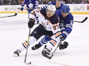 Edmonton Oilers centre Connor McDavid drives to the net as Toronto Maple Leafs defenceman Ron Hainsey defends during first period NHL hockey action in Toronto on Sunday, December 10, 2017.