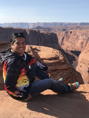 Donavon Hanley, who runs Detours Native America poses with one of his many beaded moccasins on the edge of the Horseshoe Bend that overlooks the Colorado River below. (Kim Pemberton photo)