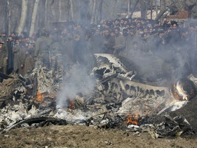 Kashmiri villagers gather near the wreckage of an Indian aircraft after it crashed in Budgam area, outskirts of Srinagar, Indian controlled Kashmir, Wednesday, Feb.27, 2019.