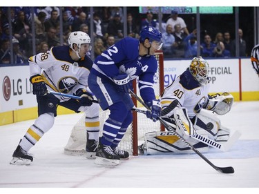 Toronto Maple Leafs Patrick Marleau C (12) and Buffalo Sabres Carter Hutton G (40) don't see the bouncing puck during the first period in Toronto on Monday February 25, 2019. Jack Boland/Toronto Sun/Postmedia Network