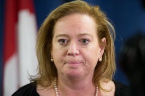 An emotional MPP Lisa MacLeod talks to the media as parents protest outside her constituency office in Barrhaven claiming that the recent funding announcement for autistic children is not nearly enough. (Wayne Cuddington/ Postmedia)