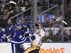 Maple Leafs centre Auston Matthews (left) and Pittsburgh Penguins centre Nick Bjugstad collide during the second period in Toronto on Saturday night. (Nathan Denette/The Canadian Press)