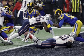 New England Patriots’ Sony Michel (26) dives over the goal line for a touchdown in front of Los Angeles Rams’ Cory Littleton (58) during Super Bowl LIII Sunday, Feb. 3, 2019, in Atlanta. (AP Photo/David J. Phillip)