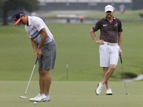 Rickie Fowler, left, putts as Jimmy Walker watches on the 18th hole during a practice round for the PGA Championship golf tournament at the Quail Hollow Club Tuesday, Aug. 8, 2017, in Charlotte, N.C. (AP Photo/Chris Carlson)