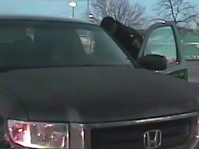 A driver of a stolen pickup truck is seen in this screengrab of a dashcam video talking to a Peel Regional Police officer moments before speeding away, (Peel Regional Police photo)