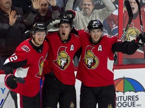 Senators right wing Mark Stone (centre) celebrates his game-winning overtime goal with teammates Thomas Chabot (left) and centre Matt Duchene (right) during NHL action against the Canadiens, in Ottawa on Oct. 20, 2018.