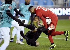 Toronto FC midfielder Jonathan Osorio (right) collides with Club Atletico Independiente goalkeeper Jose Guerra at BMO Field last night.  Nathan Denette/The Canadian Press