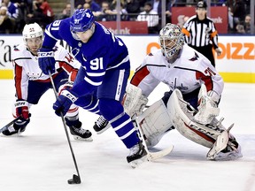 Toronto Maple Leafs centre John Tavares (91) tries to manage the puck in front of Washington Capitals goaltender Braden Holtby (70) as the Capitals' Brooks Orpik (44) looks on in Toronto on Thursday, Feb. 21, 2019. (THE CANADIAN PRESS/Frank Gunn)