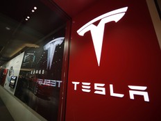 In this Feb. 9, 2019, file photo, a sign bearing the company logo is displayed outside a Tesla store in Cherry Creek Mall in Denver.