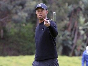 Tiger Woods warns spectators that someone is hitting behind them during the Pro-Am round of the Genesis Open golf tournament at Riviera Country Club in the Pacific Palisades area of Los Angeles on Wednesday. AP PHOTO