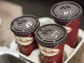 Cups of coffee sit on a counter in a Tim Hortons outlet in Oakville, Ont. on Monday Sept. 16, 2013. (THE CANADIAN PRESS/Chris Young)
