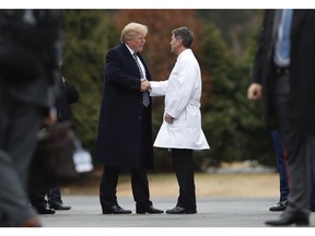 President Donald Trump shakes hands with White House physician Dr. Ronny Jackson as he boards Marine One as he leaves Walter Reed National Military Medical Center in Bethesda, Md., Friday, Jan. 12, 2018, after his first medical check-up as president.