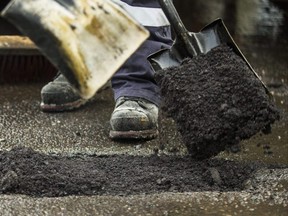 A city crew fills in a pothole near Lawrence Avenue East and Don Mills Road) in Toronto, Ont. on Friday February 22, 2019. The city will start a pothole repair blitz on Saturday, February 23.  Ernest Doroszuk/Toronto Sun/Postmedia