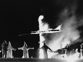 In this Sept. 27, 1987, file photo, the Invisible Empire, Ku Klux Klan members wearing traditional robes form a circle around a burning cross in Rumford, Maine.