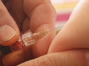 A children's doctor injects a vaccine against measles, rubella, mumps and chicken pox to an infant.