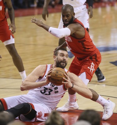 Raptors’ Marc Gasol looks to make a pass from the ground as Houston’s Chris Paul defends on Tuesday. (Veronica Henri/Toronto Sun)