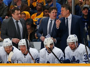 Toronto Maple Leafs head coach Mike Babcock speaks to assistant coaches Jim Hille and D.J. Smith during the second period at Bridgestone Arena on March 19, 2019 in Nashville, Tennessee.  (Frederick Breedon/Getty Images)