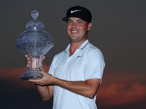 Keith Mitchell poses with the trophy after winning the Honda Classic at PGA National Resort and Spa in Palm Beach Gardens, Fla., yesterday. Getty Images)
