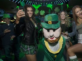 Megan Boyle, Becky Franklin, and Krista Goguen do an Irish jig with a leprechaun at Toronto's largest St. Patrick's Day party, Guinness SPD Toronto, at 11 Polson St. (Stan Behal,Toronto Sun)