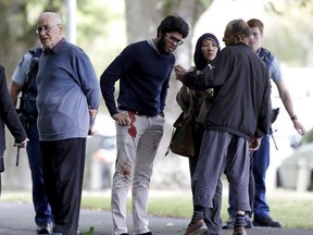People stand across the road from a mosque in central Christchurch, New Zealand, Friday, March 15, 2019. A witness says a number of people have been killed in a mass shooting at a mosque in the New Zealand city of Christchurch; police urge people to stay indoors.(AP Photo/Mark Baker)