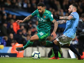 Watford striker Andre Gray (left) vies for the ball with Manchester City midfielder Bernardo Silva during their English Premier League match on Sunday. Watford is among the best midtable teams in the Premier League.  Getty Images