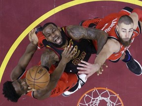 In this May 5, 2018, file photo, Cleveland Cavaliers' LeBron James 
 goes up for a shot between Toronto Raptors' OG Anunoby, left, and Jonas Valanciunas during the first half of Game 3 of an NBA basketball second-round playoff series in Cleveland.