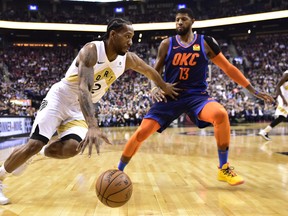 Raptors forward Kawhi Leonard (2) moves past Oklahoma City Thunder forward Paul George on Friday night. THE CANADIAN PRESS/Frank Gunn