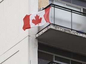 In this Sept. 28, 2011 file photo,  a Canadian flag is seen flying from the balcony of an apartment building in Ottawa.  (Andre Forget/Postmedia Network files)