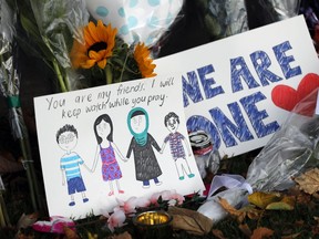 A moving message is placed at a collection of flowers left at the Botanical Gardens in Christchurch, New Zealand, on Saturday, March 16, 2019.(AP Photo/Vincent Thian)