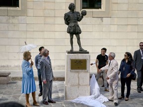 Britain's Prince Charles, second from left, and his wife Camilla, with umbrella, reveal a statue of William Shakespeare during a guided tour by City Historian Eusebio Leal, front right, as they tour the historic area of Havana, Cuba, Monday, March 25, 2019.