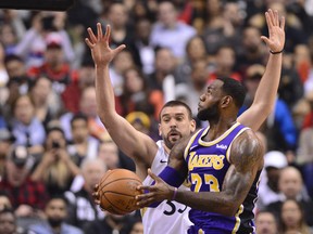 Raptors’ Marc Gasol (left) tries to block Los Angeles Lakers’ LeBron James during Thursdday’s game in Toronto. (THE CANADIAN PRESS)