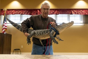 Joie Henney lifts his emotional support animal, Wally, onto a table during a presentation at the SpiriTrust Lutheran Village at Sprenkle Drive in York, Pa. (Ty Lohr/York Daily Record via AP)