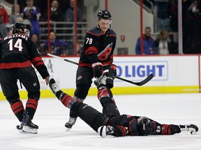 Carolina Hurricanes' Justin Williams and Micheal Ferland drag Jordan Martinook from the ice following the team's celebration following an NHL game in Raleigh, N.C., Friday, March 1, 2019.