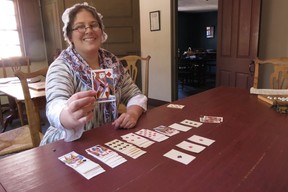 Playing solitaire, re-enactor Katie Raynes portrays Margaret Davis, second daughter of John Stavers, owner of a tavern in Strawberry Banke Museum’s living history village near the Portsmouth, N.H. waterfront. (Ian Robertson)