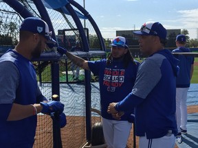 Former Jays great Roberto Alomar (right) talks with infielders Lourdes Gurriel Jr. (left) and Freddy Galvis outside the batting cage at Dunedin Stadium yesterday. Alomar says Gurriel will do a fine job as the Jays starting second baseman, at least until the return of Devon Travis.  Don Brennan/Postmedia Network