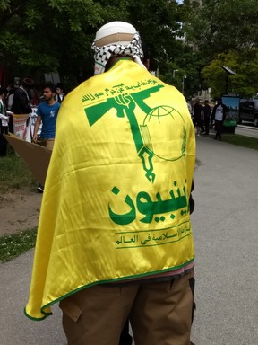 Man wearing the flag of terrorist group Hezbollah during an al-Quds day rally in Toronto, Ont. on Saturday, June 9 2018.