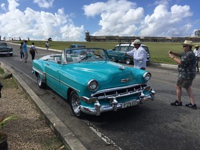Tourists rush to snap pictures of a vintage Chevy during a visit to El Morro fortress. Classic cars are one of Cuba's signature sights. Many have been restored for use as tourist taxis. Visitors will also see vintage Ladas in Old Havana, but the boxy Russian-built autos are not nearly as attractive as the American-built beauties. ROBIN ROBINSON PHOTO