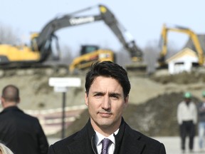 Heavy machinery is lined up behind Prime Minister Justin Trudeau as he waits to speak at a press conference highlighting the first-time home buyer incentive, at Tamarack Homes' Cardinal Creek Village development in Ottawa on Wednesday, March 20, 2019. THE CANADIAN PRESS/Justin Tang