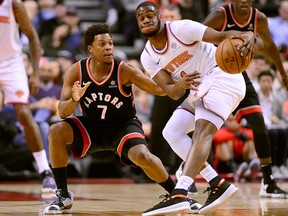 Toronto Raptors guard Kyle Lowry and New York Knicks guard Emmanuel Mudiay vie for control of a loose ball during first half NBA basketball action in Toronto, Monday, March 18, 2019.