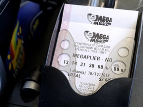 In this Oct. 17, 2018, file photo, Mega Millions lottery tickets are printed out of a machine at a convenience store in Chicago. (AP Photo/Nam Y. Huh, File)