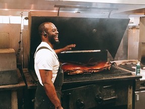 Chef Dillard Johnson tends to a whole hog gently smoking at The Pit in Raleigh, N.C. (KEVIN HANN)